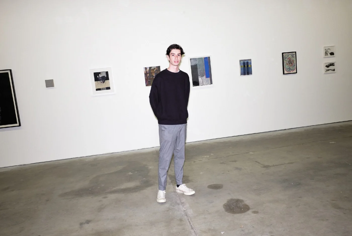 A visitor in front of works in From Out Under at Appointment Only, Los Angeles
