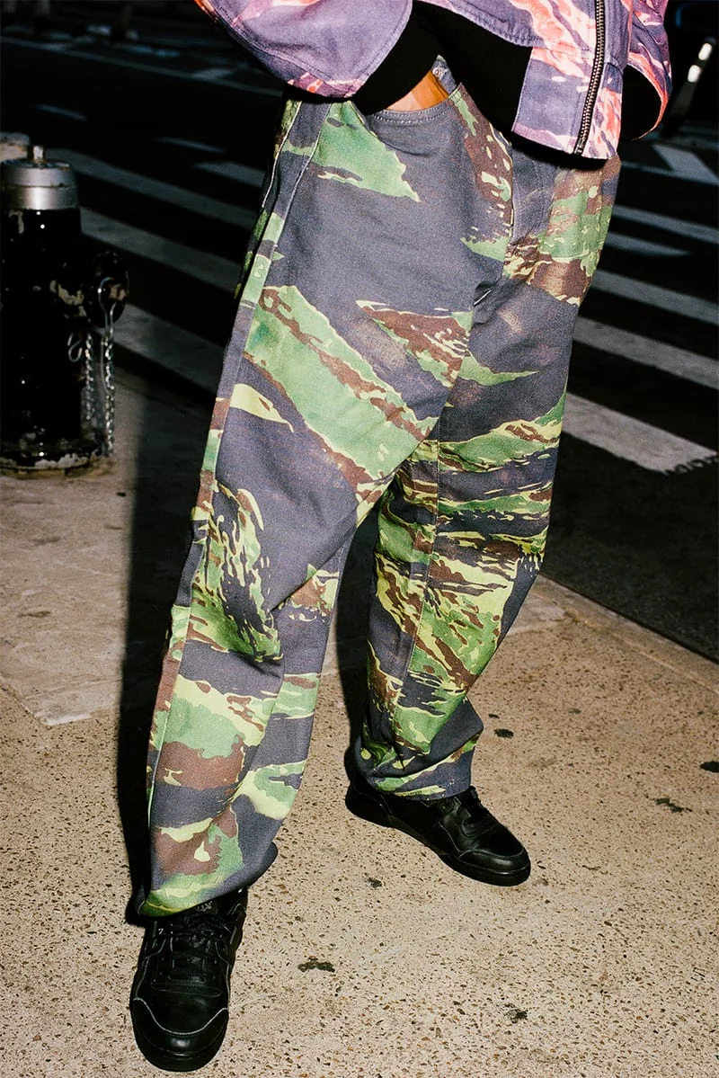 Detail of the purple bomber jacket and green trousers from the Stüssy and Lucien Smith Tigris collaboration, worn by Armando Nin